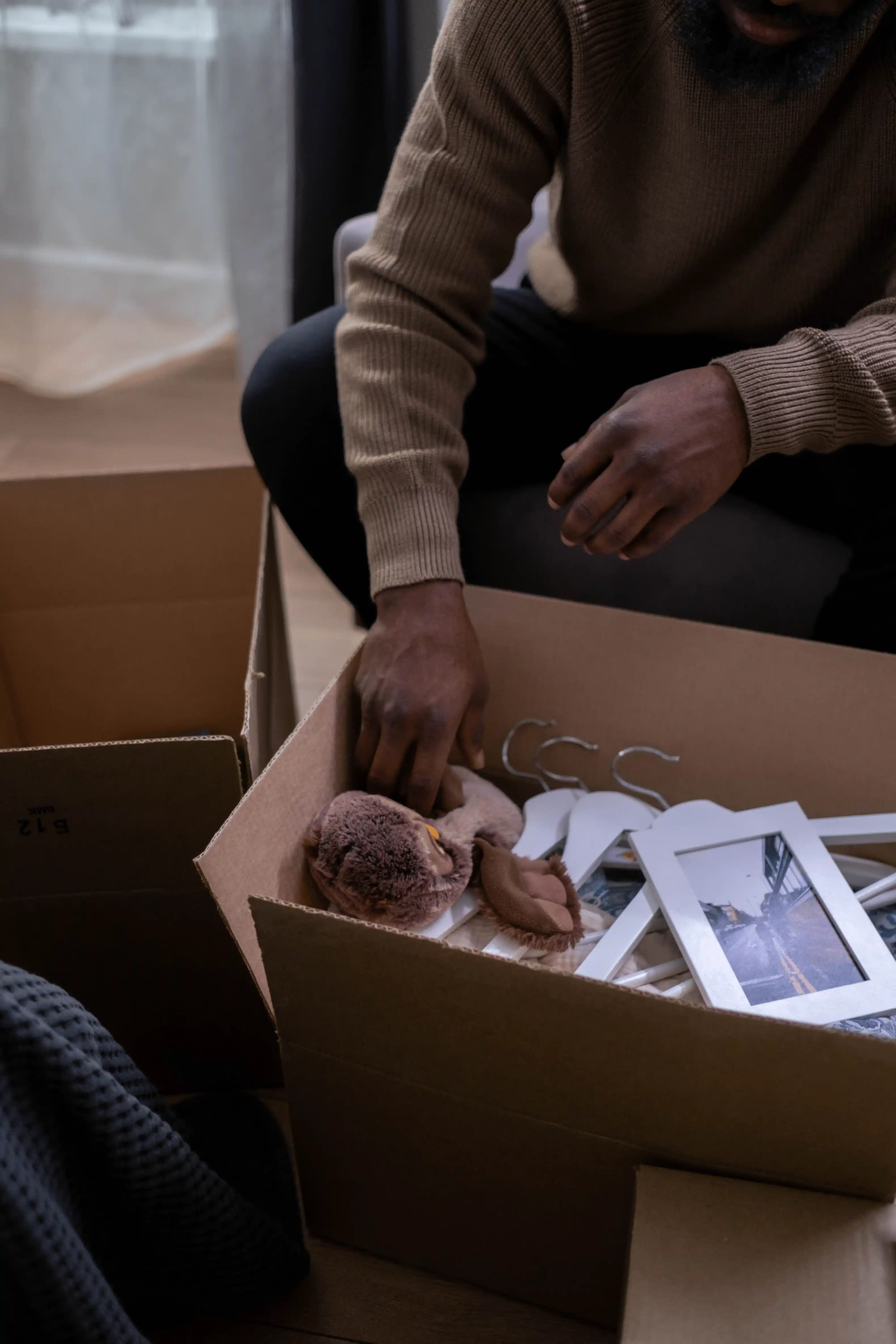 Boxes in a dated living room representing the heavy emotional cleanout of an inherited property