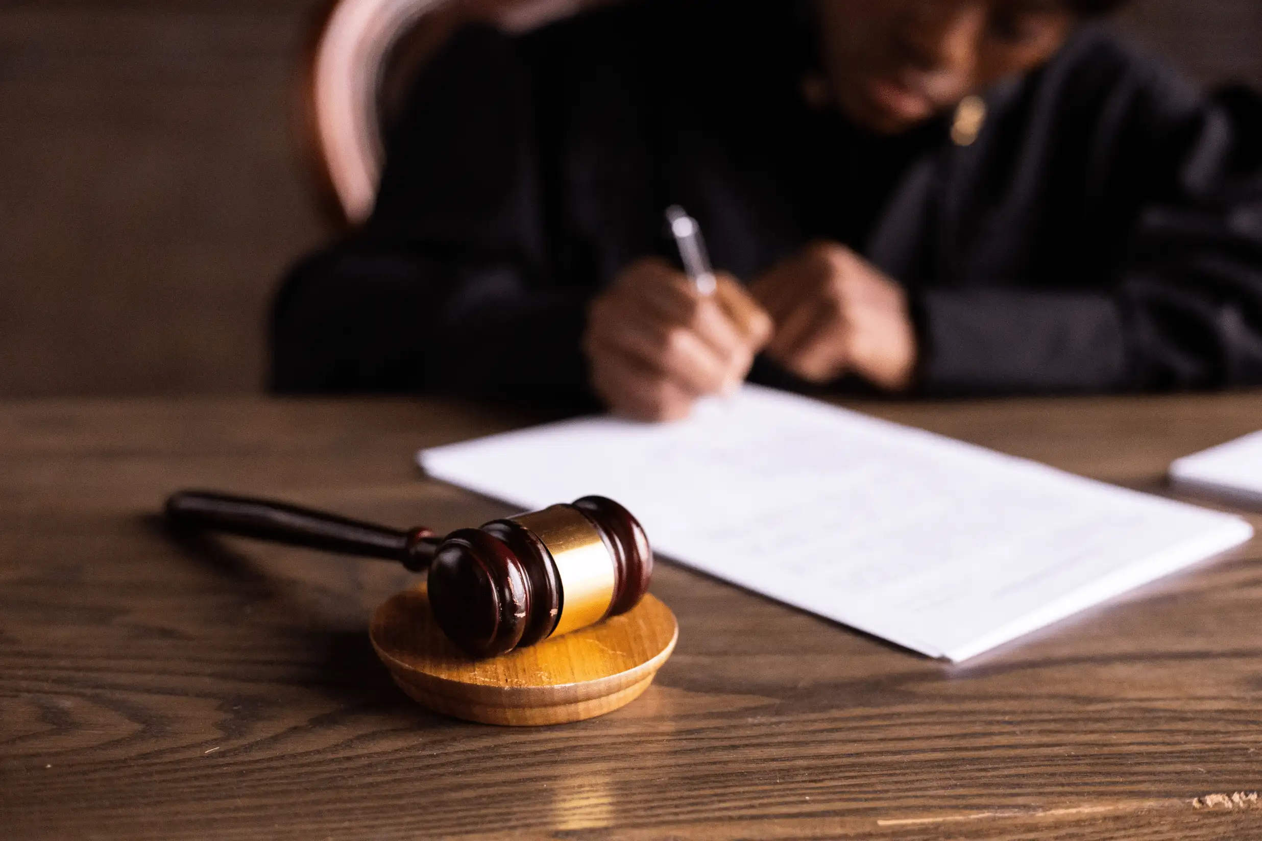 A stack of legal documents and eviction notices on a wooden desk