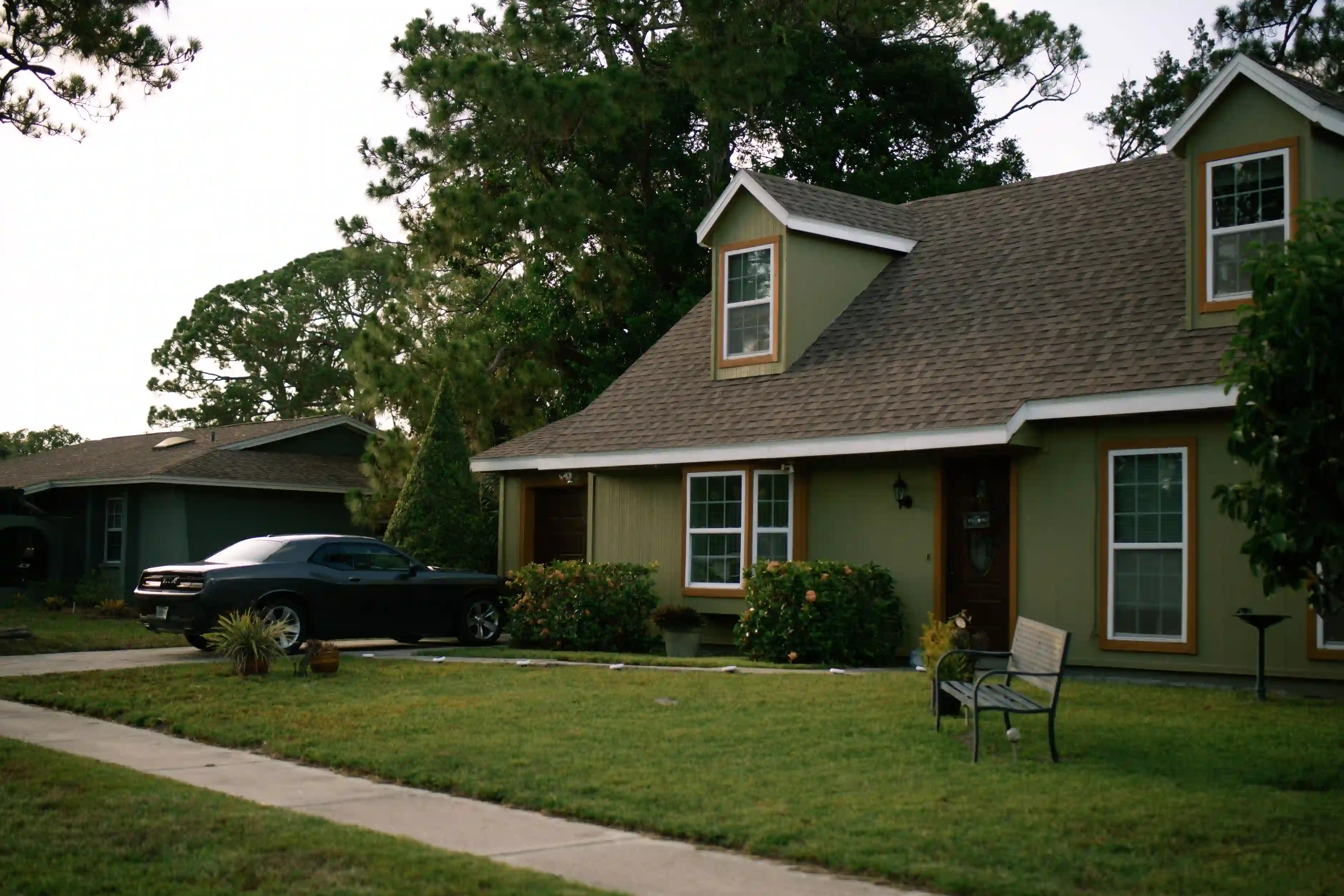 An exterior view of a vacant residential home in a Florida neighborhood with overgrown lawn