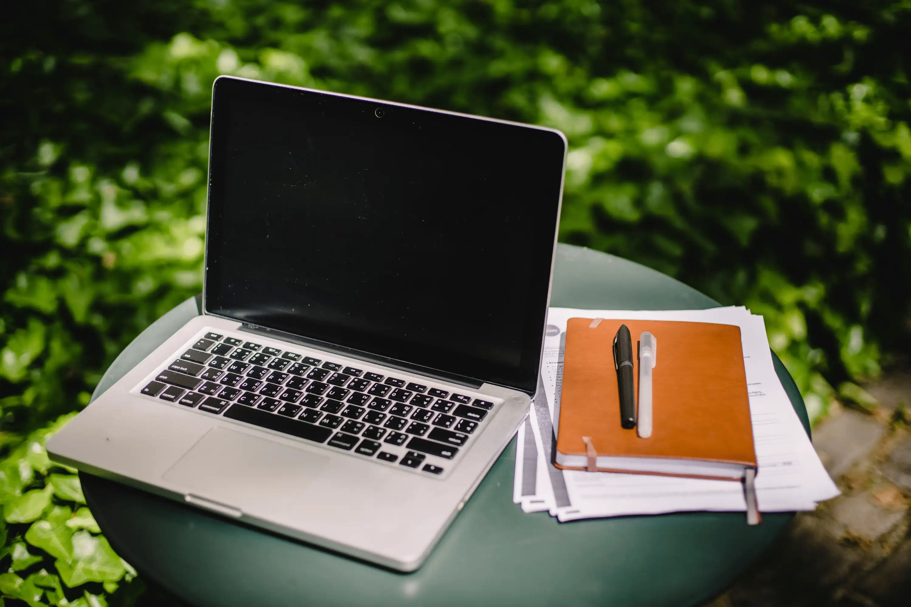 A laptop and coffee cup on a table, representing remote work and closing a real estate transaction from home