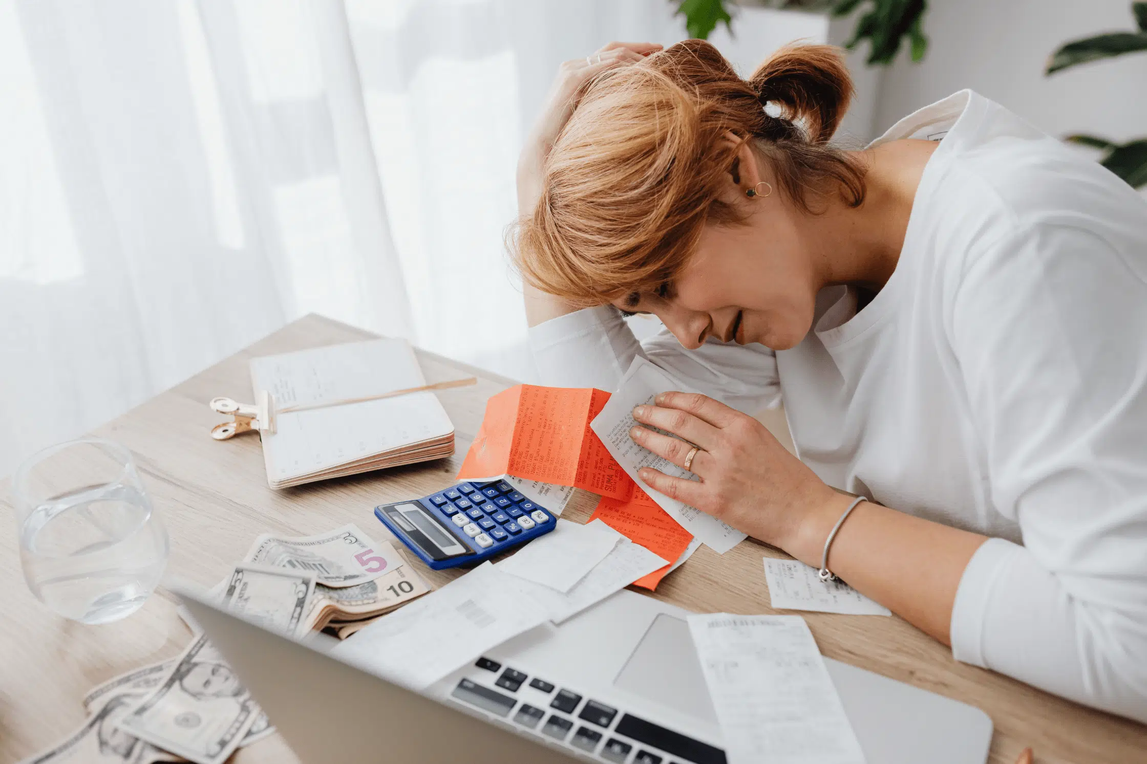A stressed homeowner reviewing paperwork and looking for foreclosure options
