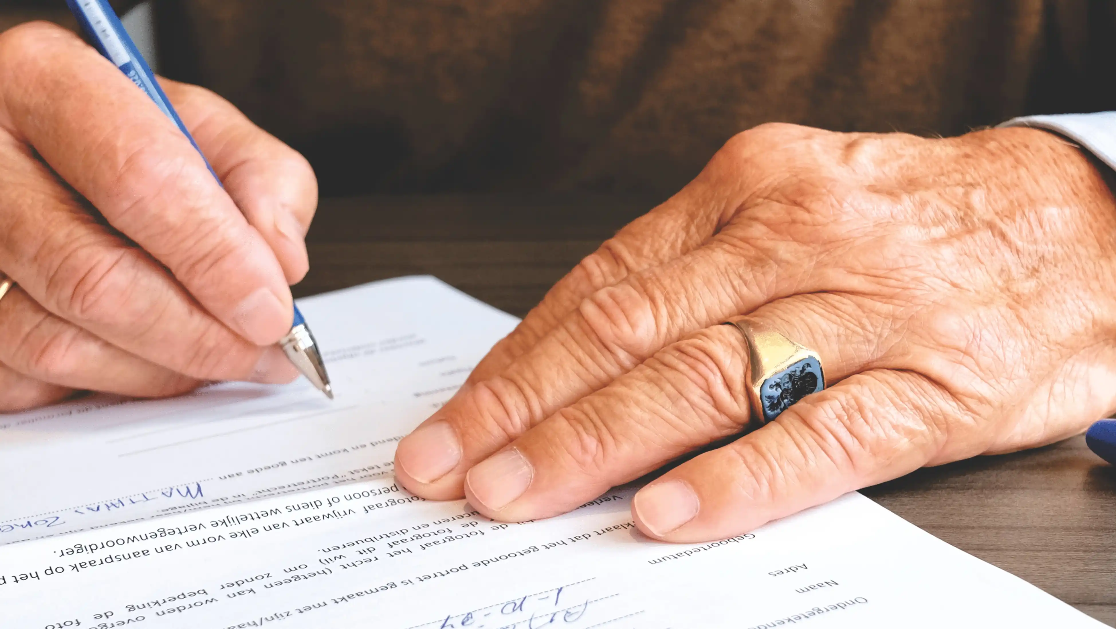 Smiling homeowner signing final closing documents at a table