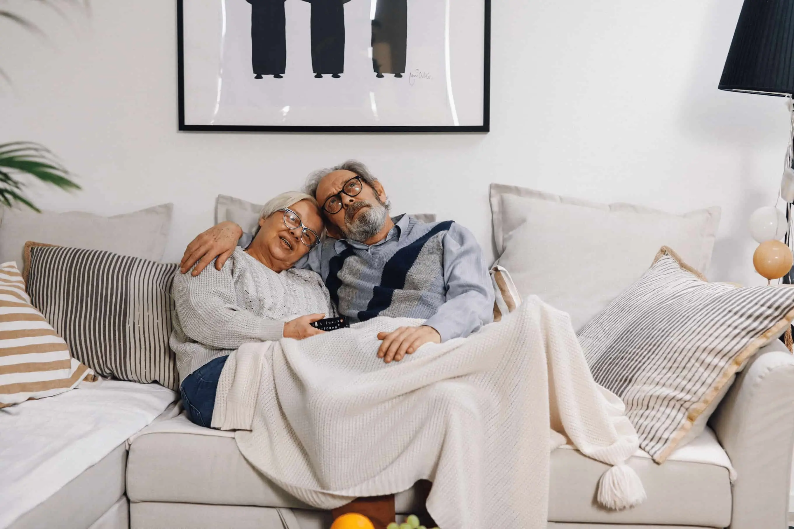 An Atlanta senior couple sitting comfortably in their living room reviewing home sale paperwork together