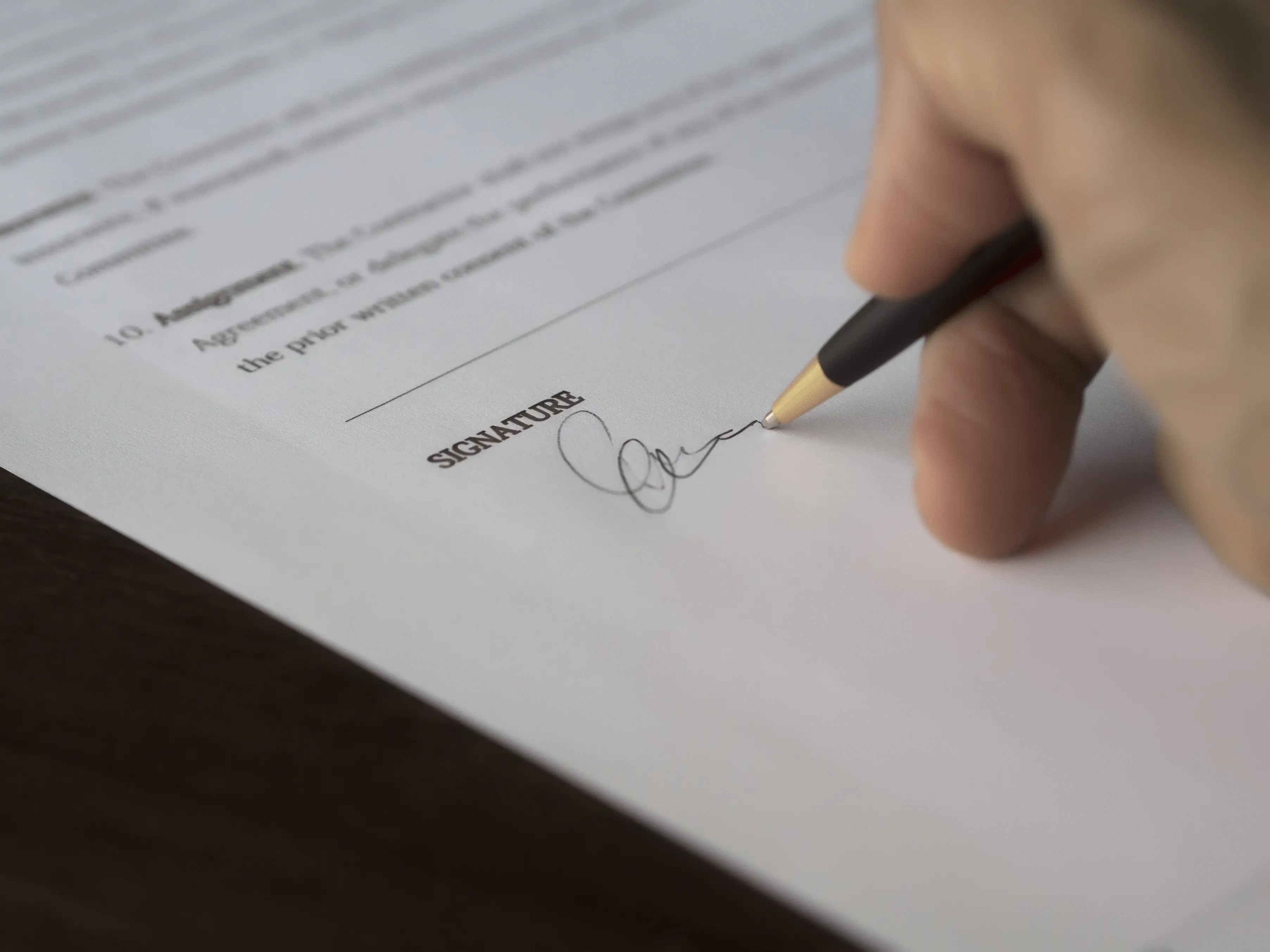 A pair of hands reviewing legal family court documents and financial paperwork on a desk